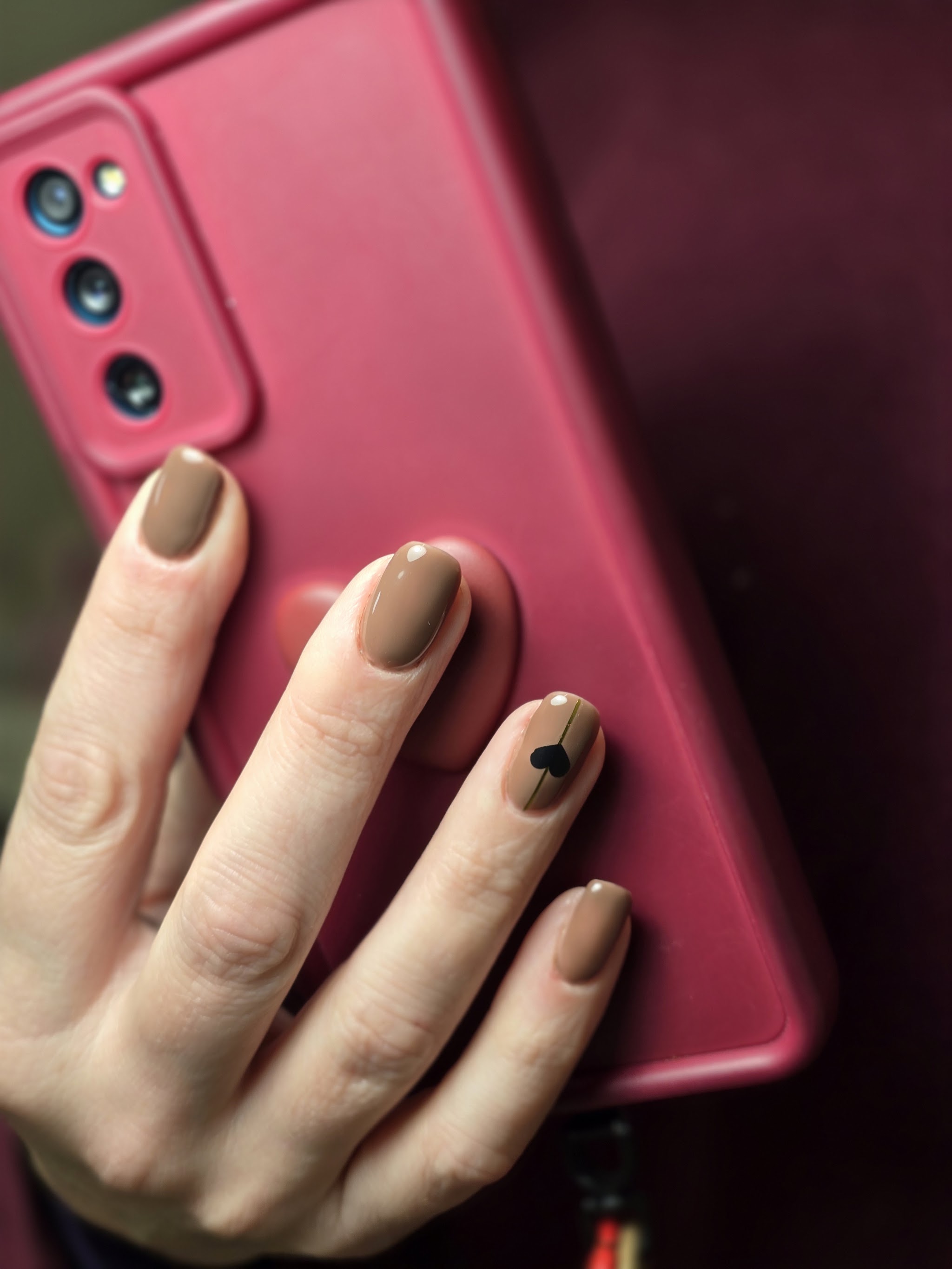 Taupe nagels met een klein zwart hartje op één nagel
